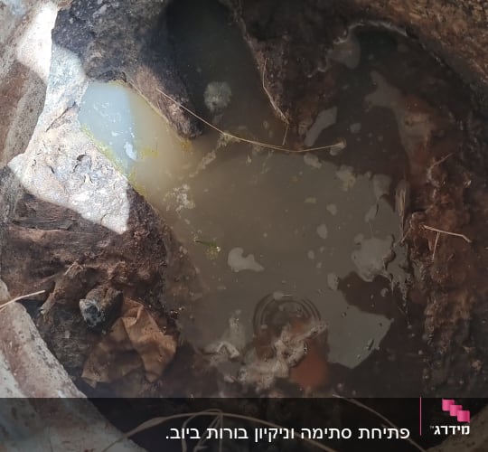 בור עם מים עכורים ואדמה רטובה